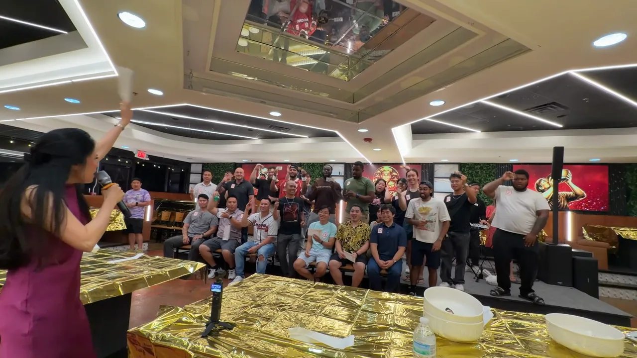 The emcee leads a cheer in front of a full room at the Pho Challenge